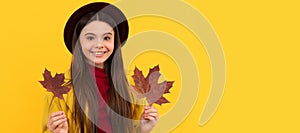 happy teen girl in hat and coat with autumn maple leaves on yellow background. Autumn fall child for poster design