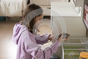 Happy teen girl have fun playing with domestic mouse