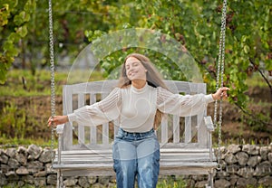 happy teen girl having free time outside on swing, summer