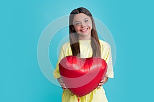 Happy teen girl hold red heart party balloon for valentines day, love symbol, be my valentine. Happy kids face, positive