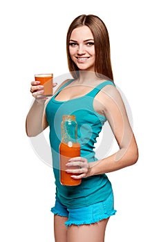 Happy teen girl holding a glass of carrot juice