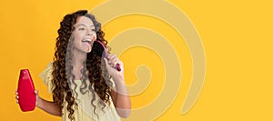 happy teen girl with long curly hair hold shampoo bottle singing in hairbrush, fun. Banner of child girl hair care