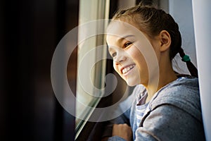 Happy teen girl look out of window outside. recovered.