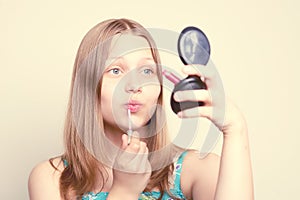 Happy teen girl looking at the mirror