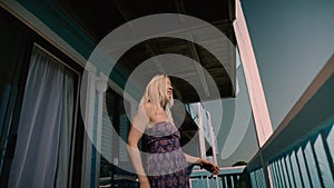 Happy teen girl relaxing at the hotel`s apartments on the bed. Girl is locking at the window. Summer vacation mood