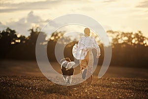Happy teen girl running with her dog on field