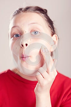 Happy teen girl with scrub mask on her face