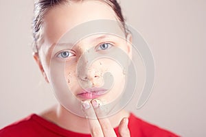 Happy teen girl with scrub mask on her face