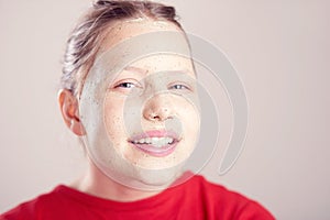 Happy teen girl with scrub mask on her face