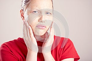 Happy teen girl with scrub mask on her face