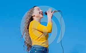 happy teen girl singing karaoke in microphone