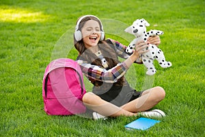 Happy teen girl singing song on grass after school, music. back to school. pupil at school time.