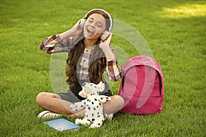 Happy teen girl singing song on grass after school, music. back to school. pupil at school time.