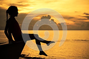 Happy teen girl sitting on beach