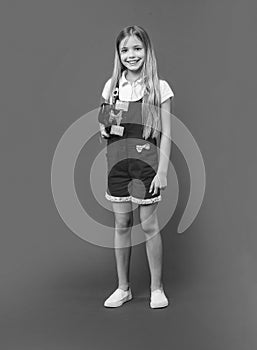 happy teen girl skateboarder isolated on purple. teen girl skateboarder in studio. photo