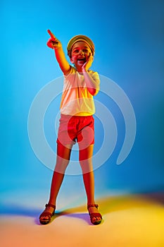 The happy teen girl standing and smiling against blue background.