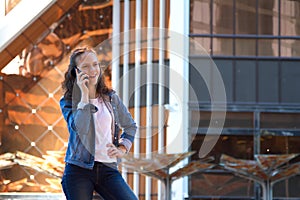 Teen girl having a mobile phone talk in a large metropolis