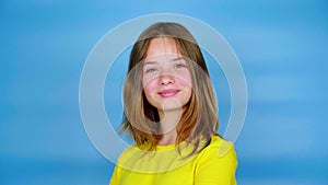 Happy teen girl in a yellow t-shirt is turns to the camera and smiles