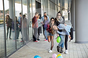 Happy teen girls and boys having good fun time outdoors