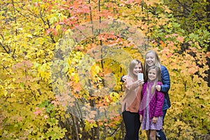 Happy teen girls taking selfie in park