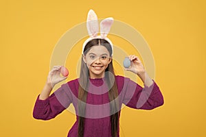 happy teen kid in bunny ears with painted eggs for easter, egg hunt