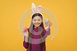 happy teen kid in bunny ears with painted eggs for easter, egg hunt