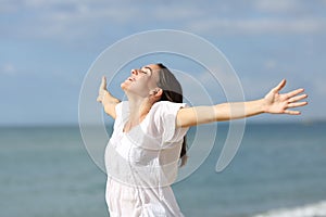 Happy teen outstretching arms on the beach a sunny day