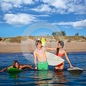 Happy teen surfers talking on beach shore