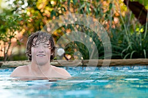 Happy teen in swimming pool with copy space.