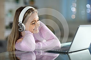 Happy teen watching videos on laptop in the night