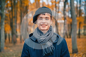 Happy teenage boy in the autumn sunny park