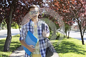 Happy teenage boy caucasian student with backpack going to high school. Outdoor portrait