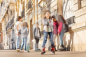 Happy teenage boy rollerblading with friends