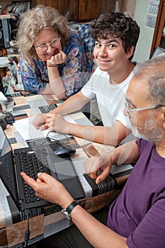 Happy Teenage Boy Smiling while being Taught by his Grandparents at Home