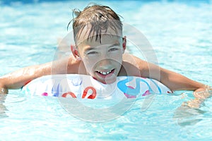 Happy teenage boy sweeming in pool