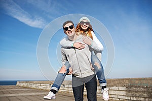 Happy teenage couple in shades having fun outdoors