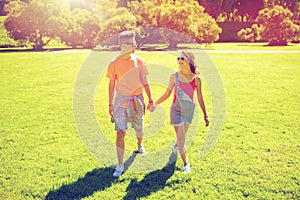 Happy teenage couple walking at summer park