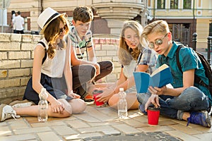 Happy 4 teenage friends or high school students reading books. Friendship and people concept