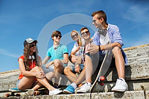 Happy teenage friends with longboard on street