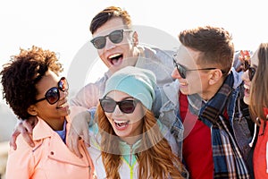 Happy teenage friends in shades laughing outdoors