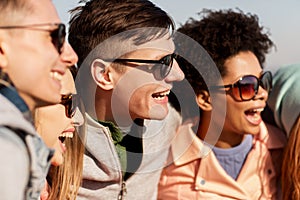 Happy teenage friends in shades laughing outdoors