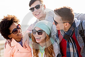 Happy teenage friends in shades laughing outdoors