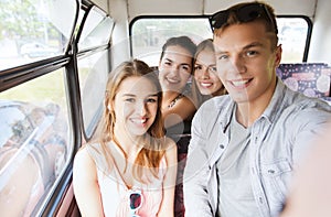 Happy teenage friends traveling by bus