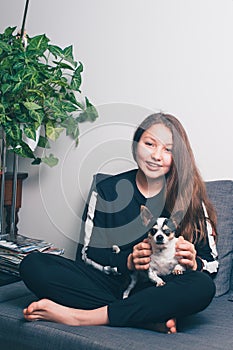 Happy teenage girl with brace at Home with chihuahua dog
