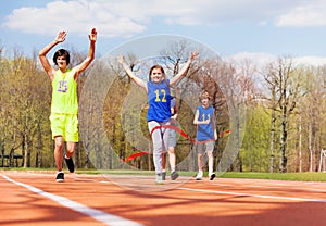 Happy teenage girl crossing finish line in race