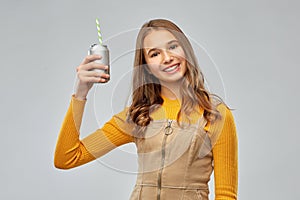 Happy teenage girl drinking soda from can