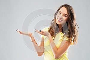 Happy teenage girl holding something imaginary