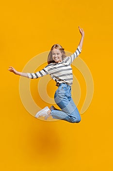 Happy teenage girl jumping in air, pretending she is flying