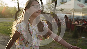 Happy teenage girl jumping outside. Girl making rhythmical movements in park