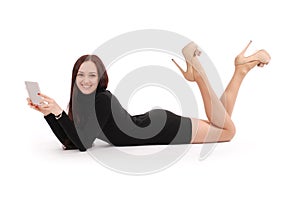 Happy teenage girl lying on the floor with tablet pc
